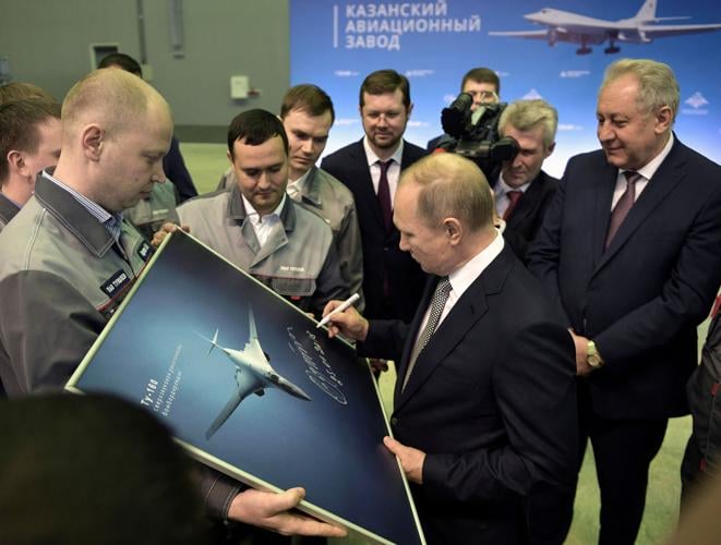 FILE PHOTO: Russian President Vladimir Putin signs a picture of a TU-160M nuclear bomber during a visit to the Gorbunov Aviation factory in Kazan